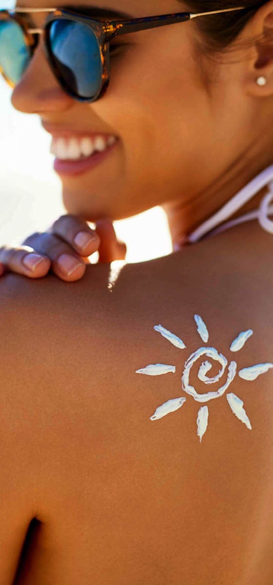 immagine di una ragazza, in spiaggia, presa di lato che sorride